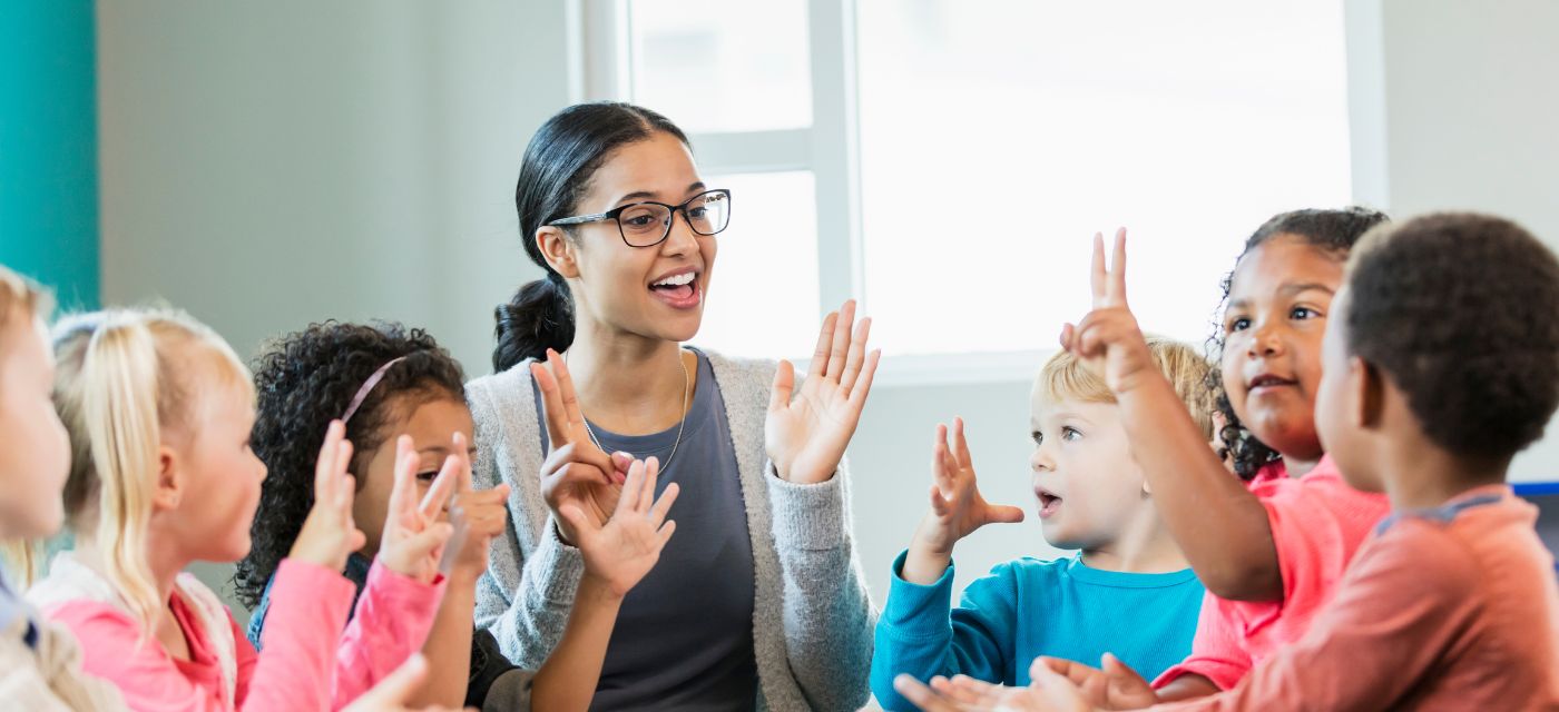 Teacher with group of preschool children around a table.